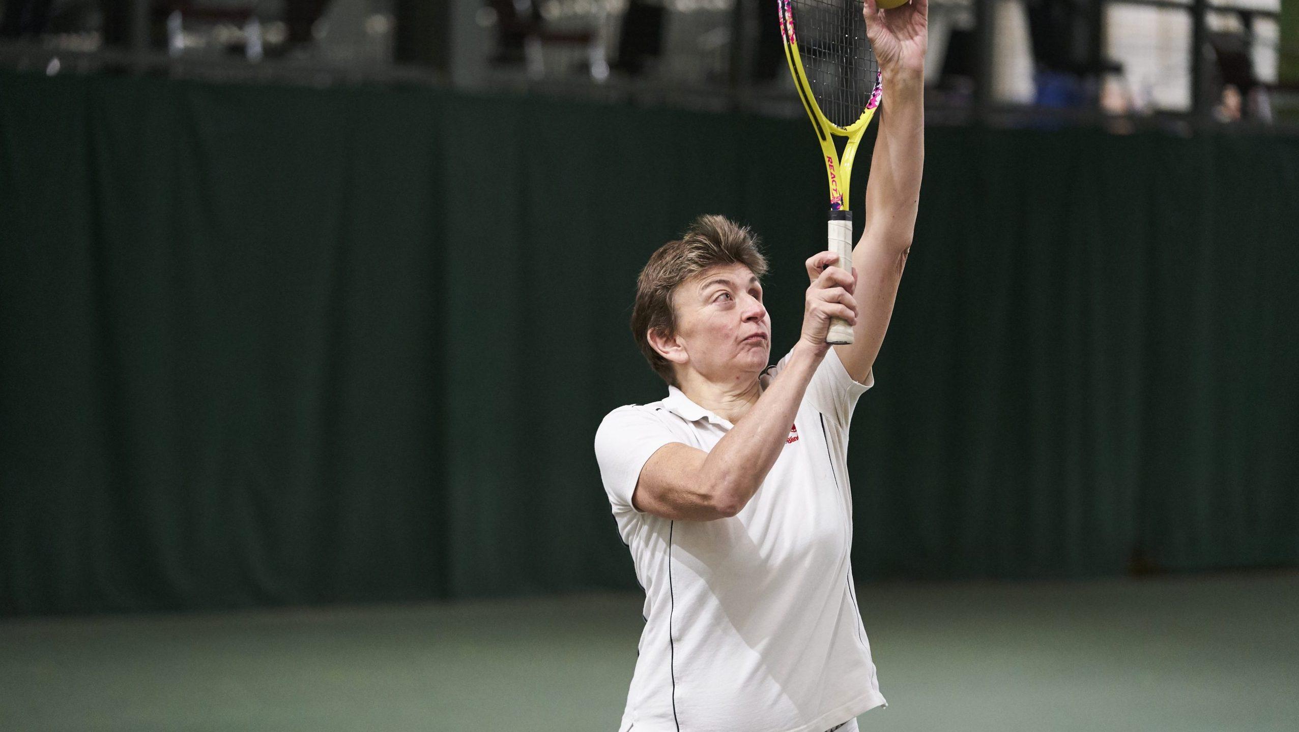 White woman with visual impairment playing tennis