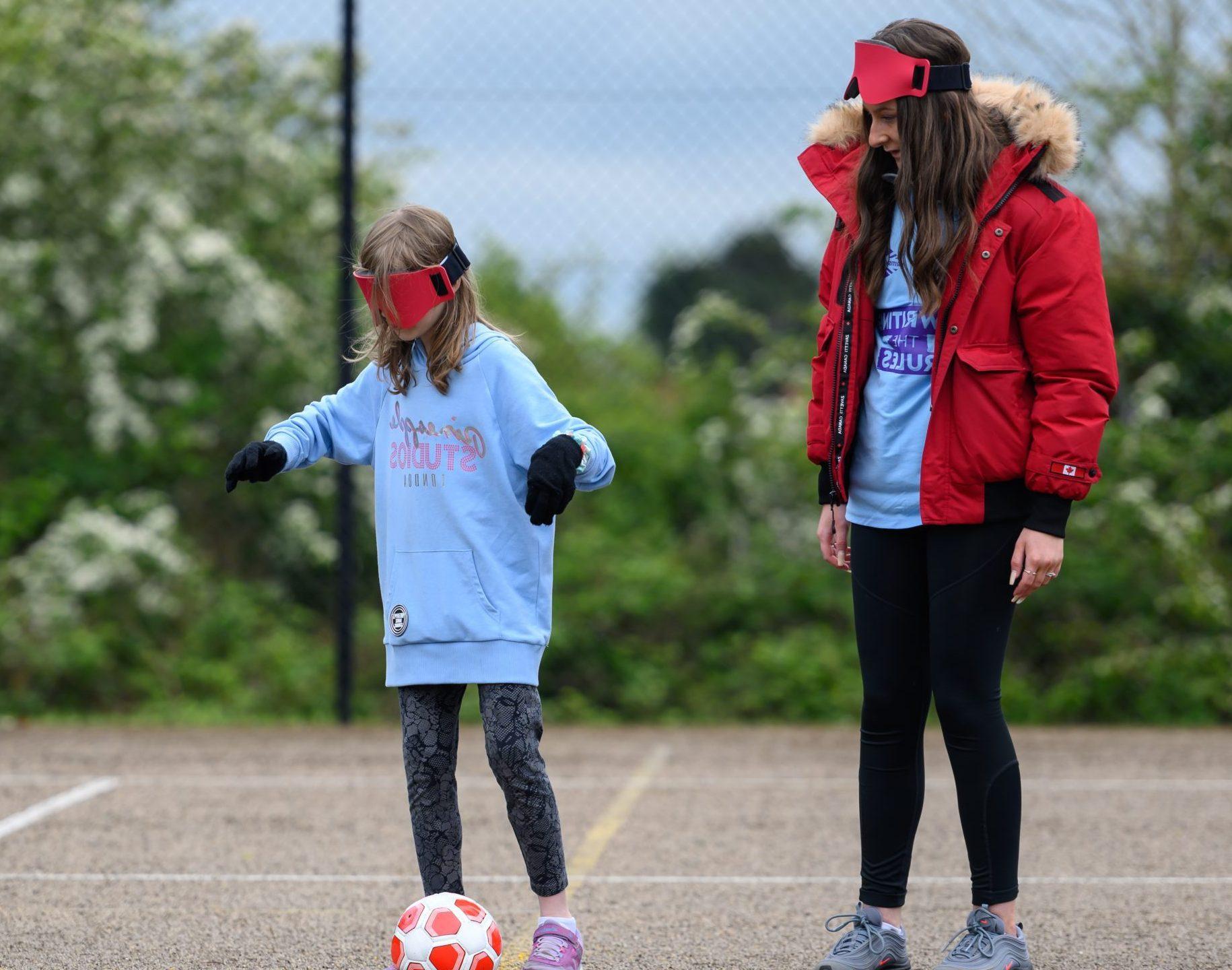 Teenage girl volunteering at a football game for younger girls with disabilities