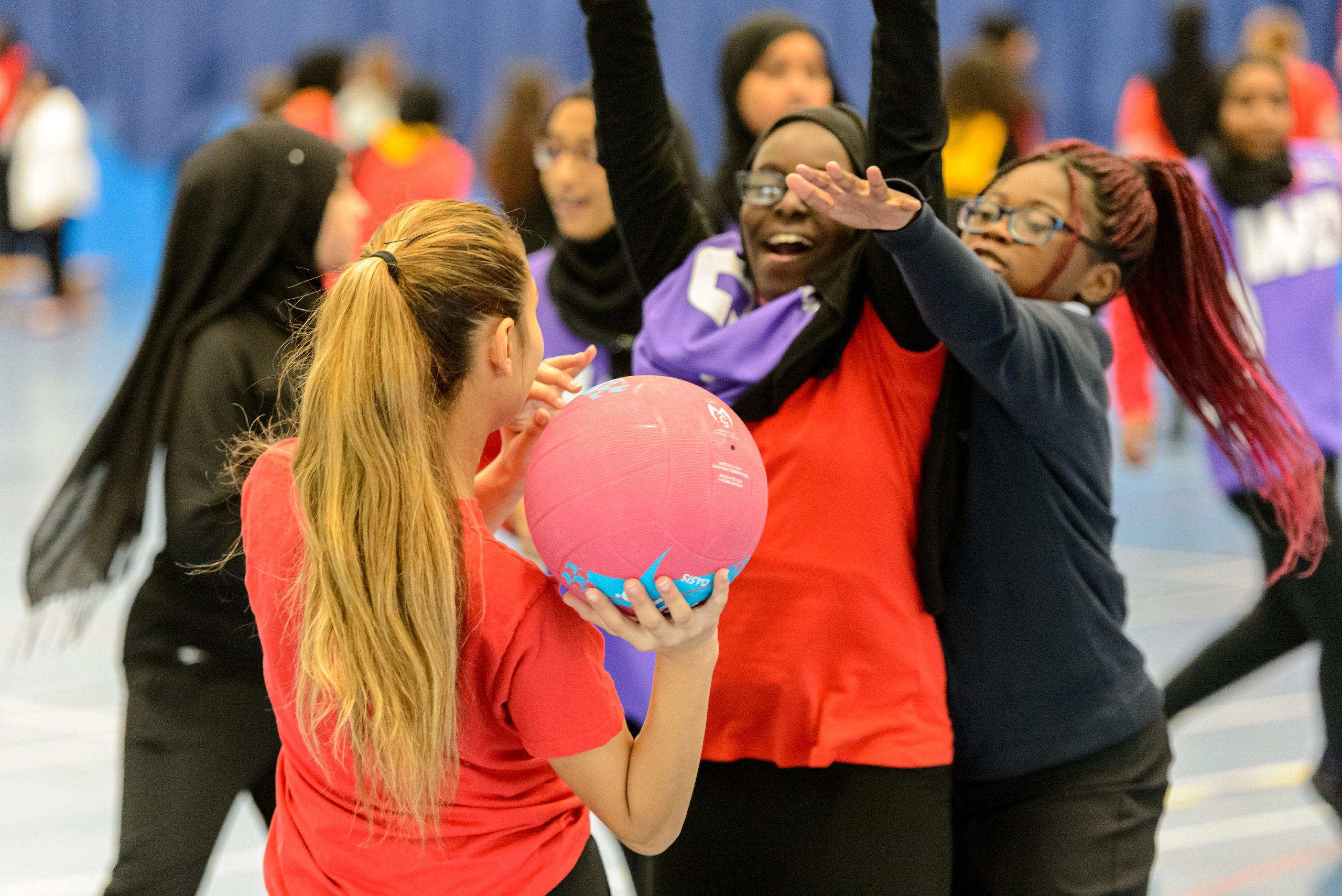 A group of teenagers from different backgrounds playing school netball