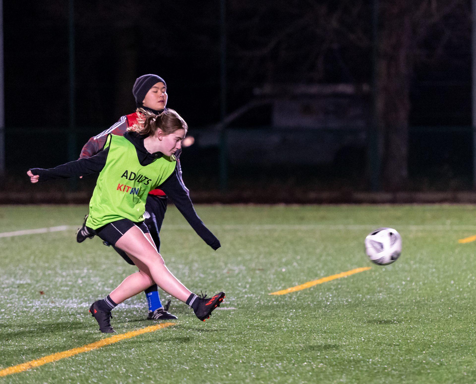 Two girls playing football