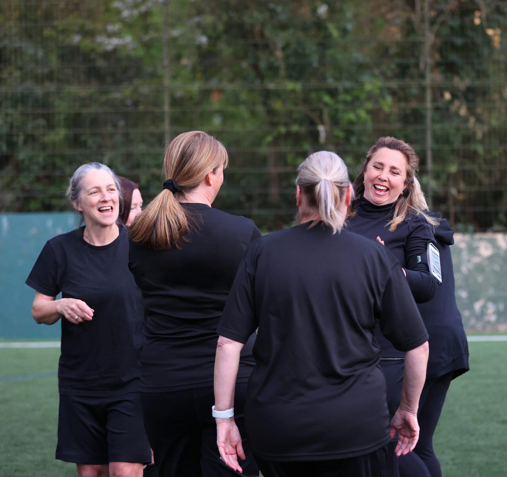 A group of white women aged 40-60 chatting during their football session