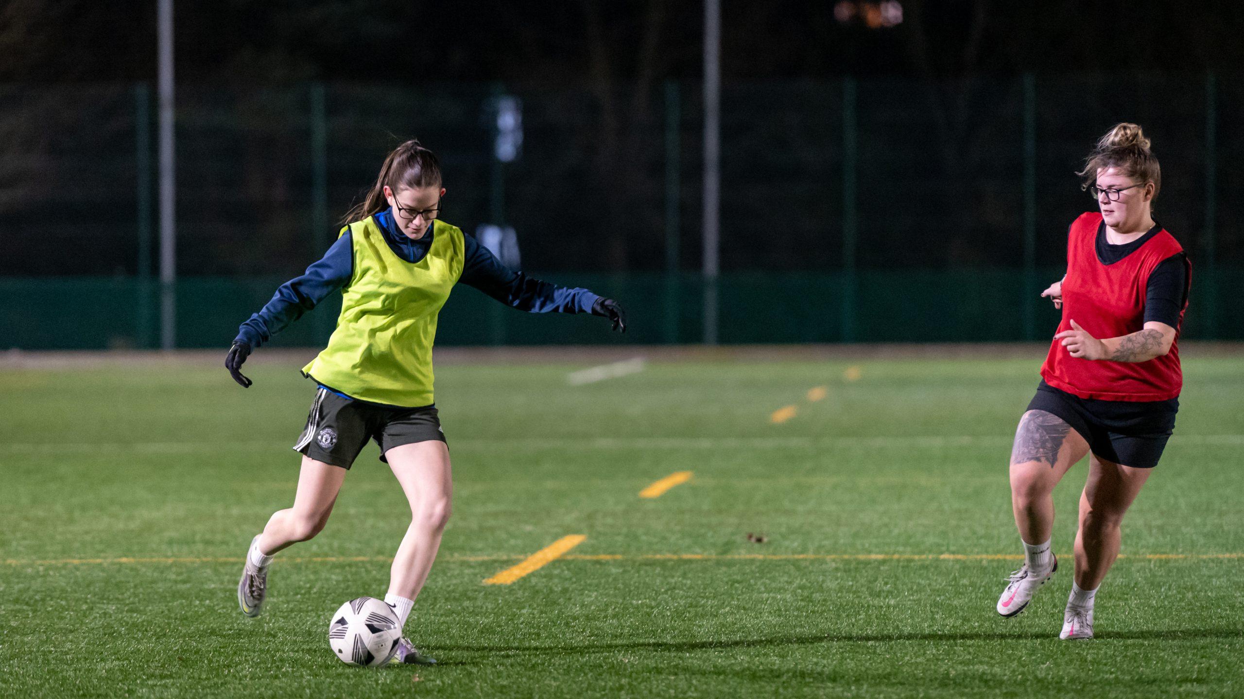 Two young women playing football