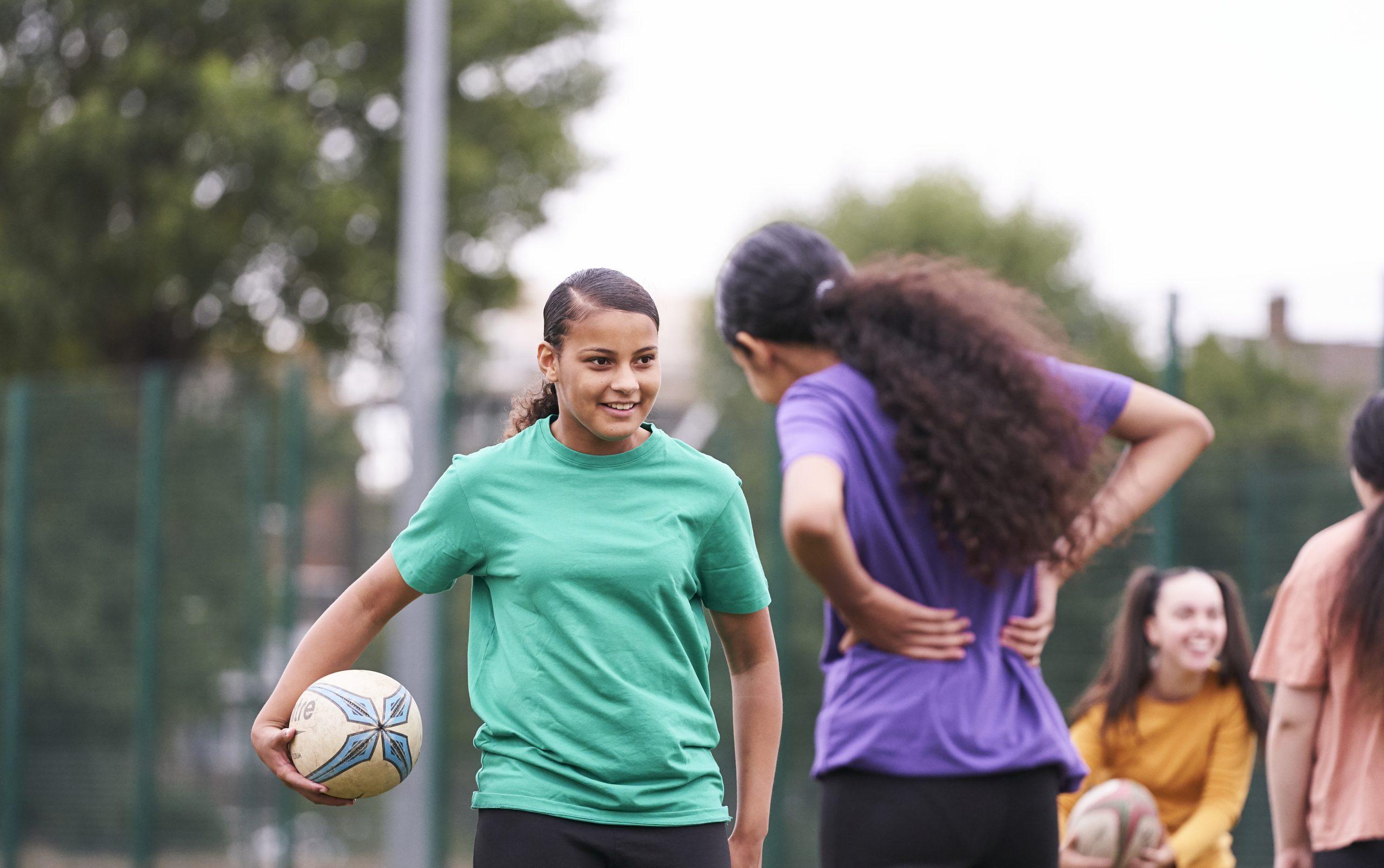 Two teenage girls playing rugby