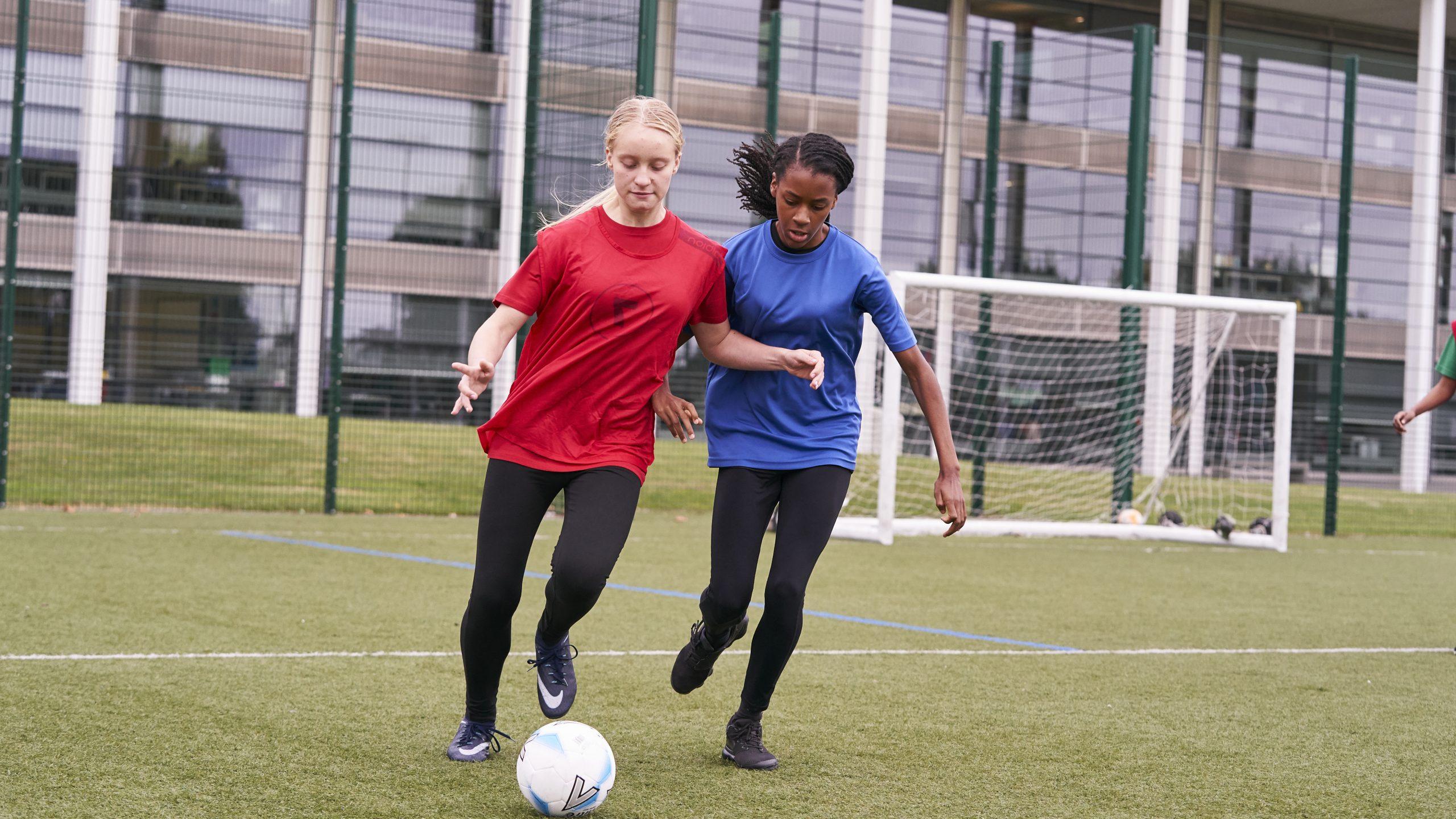 Two girls playing football