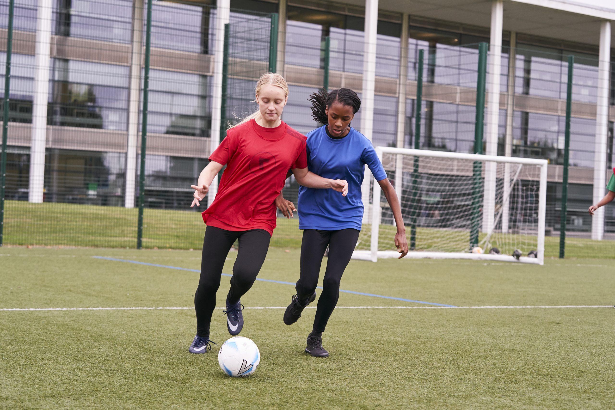 Two girls playing football