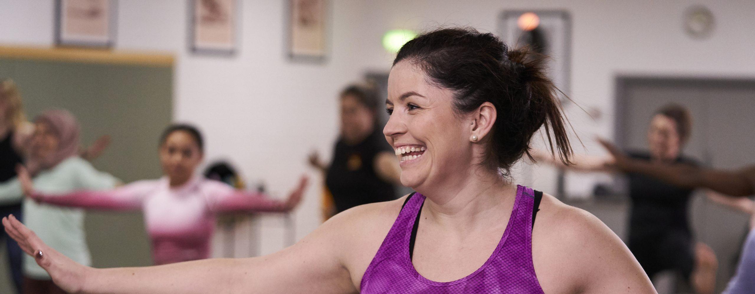 Woman aged 40-45 smiling practicing pilates