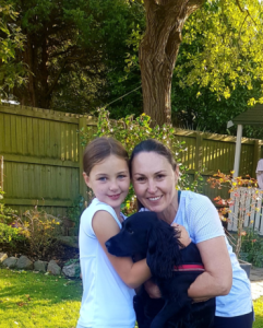 Lara and Clare with their black fluffy dog