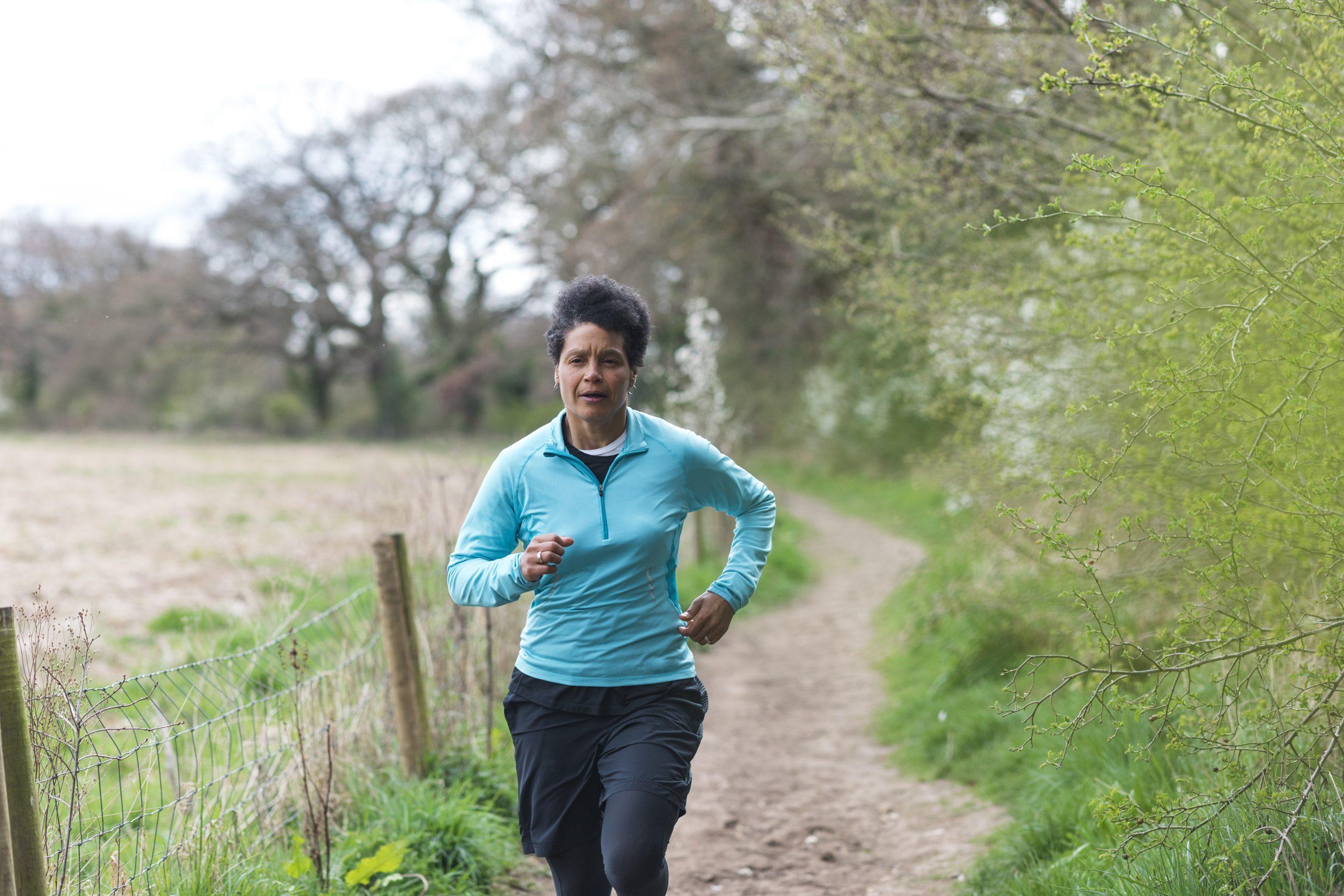 Nina, a 48 year old black woman, running on a local trail