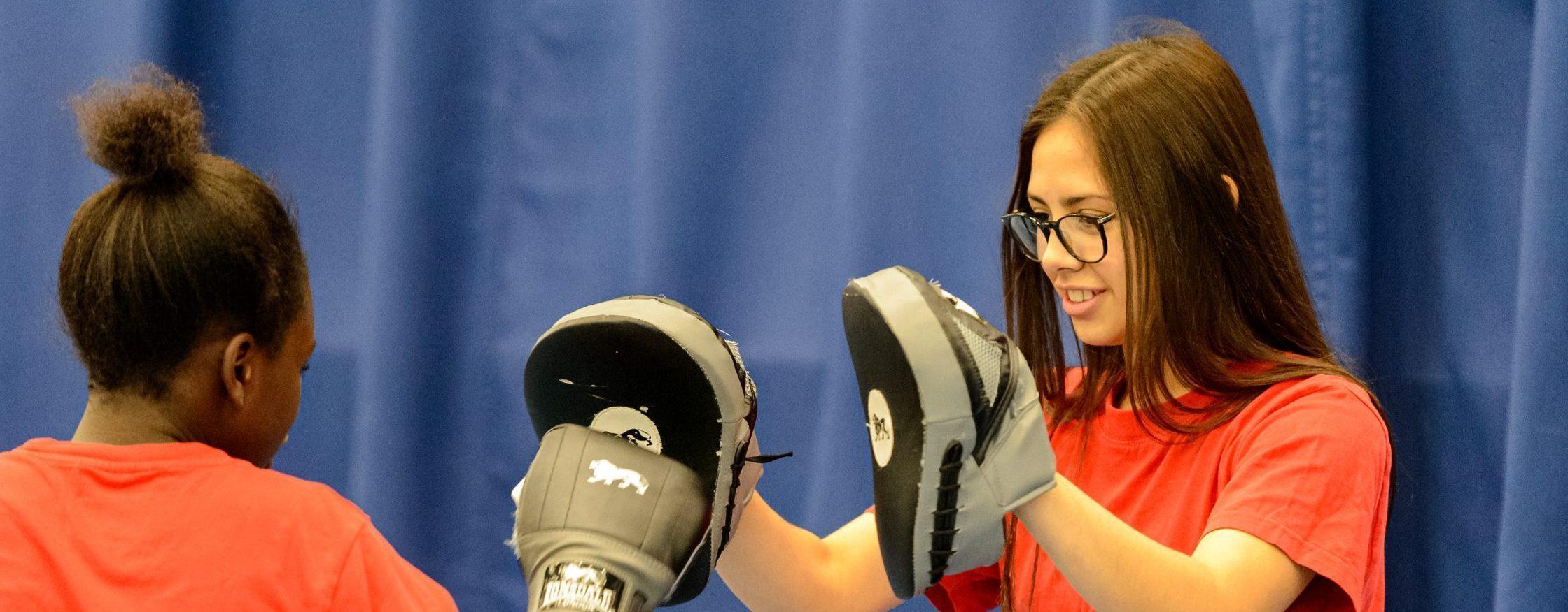 Two high school girls practicing boxing