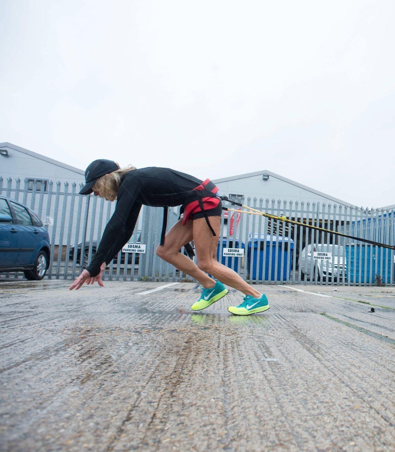 Rosie training by pulling a car via a cable wrapped round her waist