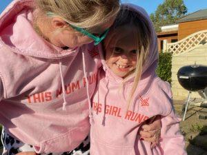 A mum wearing a hoodie that says "This Mum Runs" and her daughter wearing a hoodie reading "This Girl Runs"