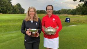 Tracey and Amelia holding golf trophies