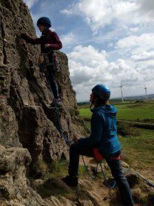 Freya climbing while her mum ruth belays her