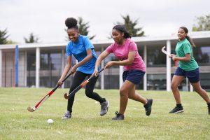 Teenage girls playing hockey