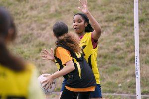 Two black teenage girls playing netball