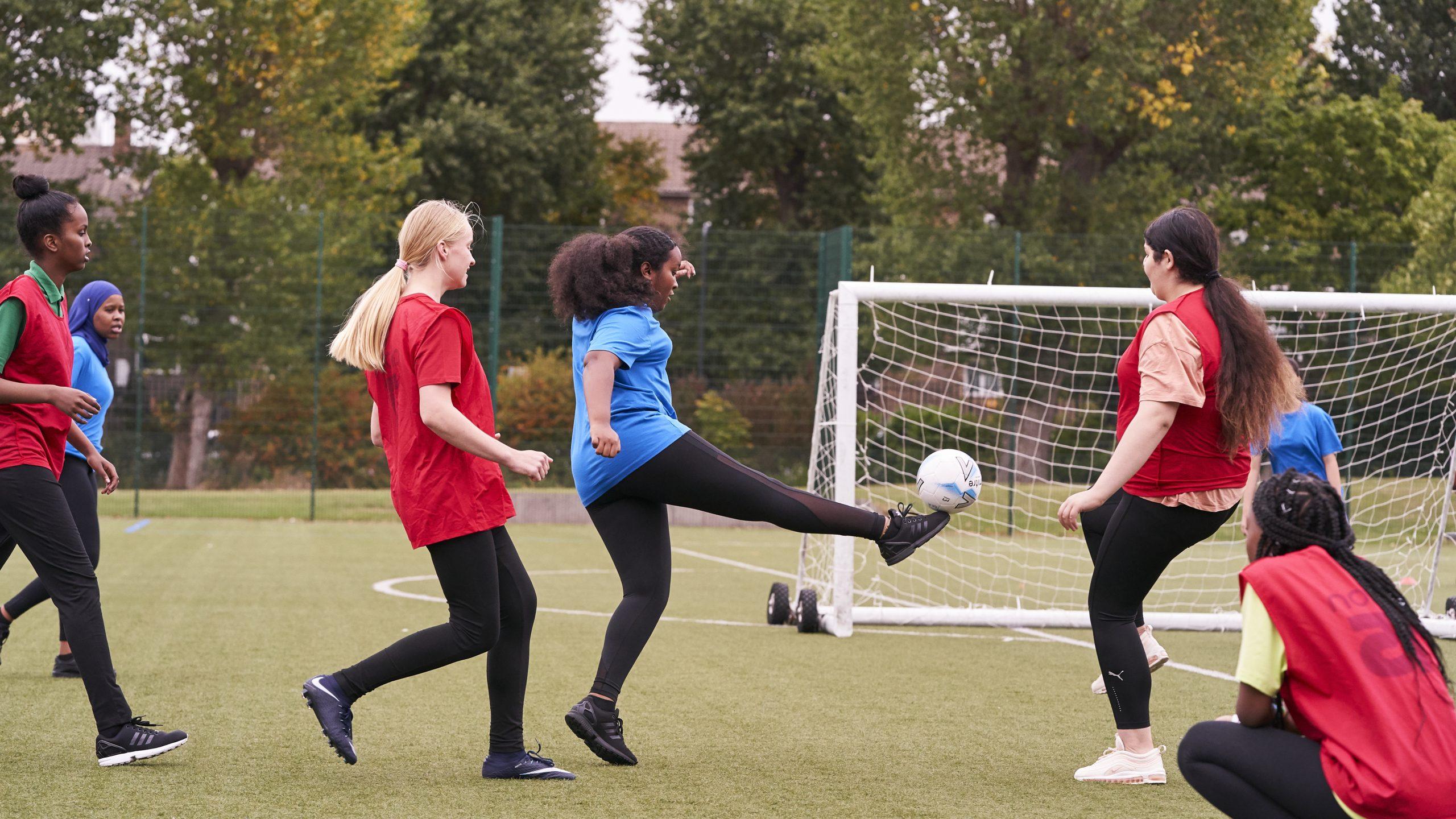 Teenage girls playing football