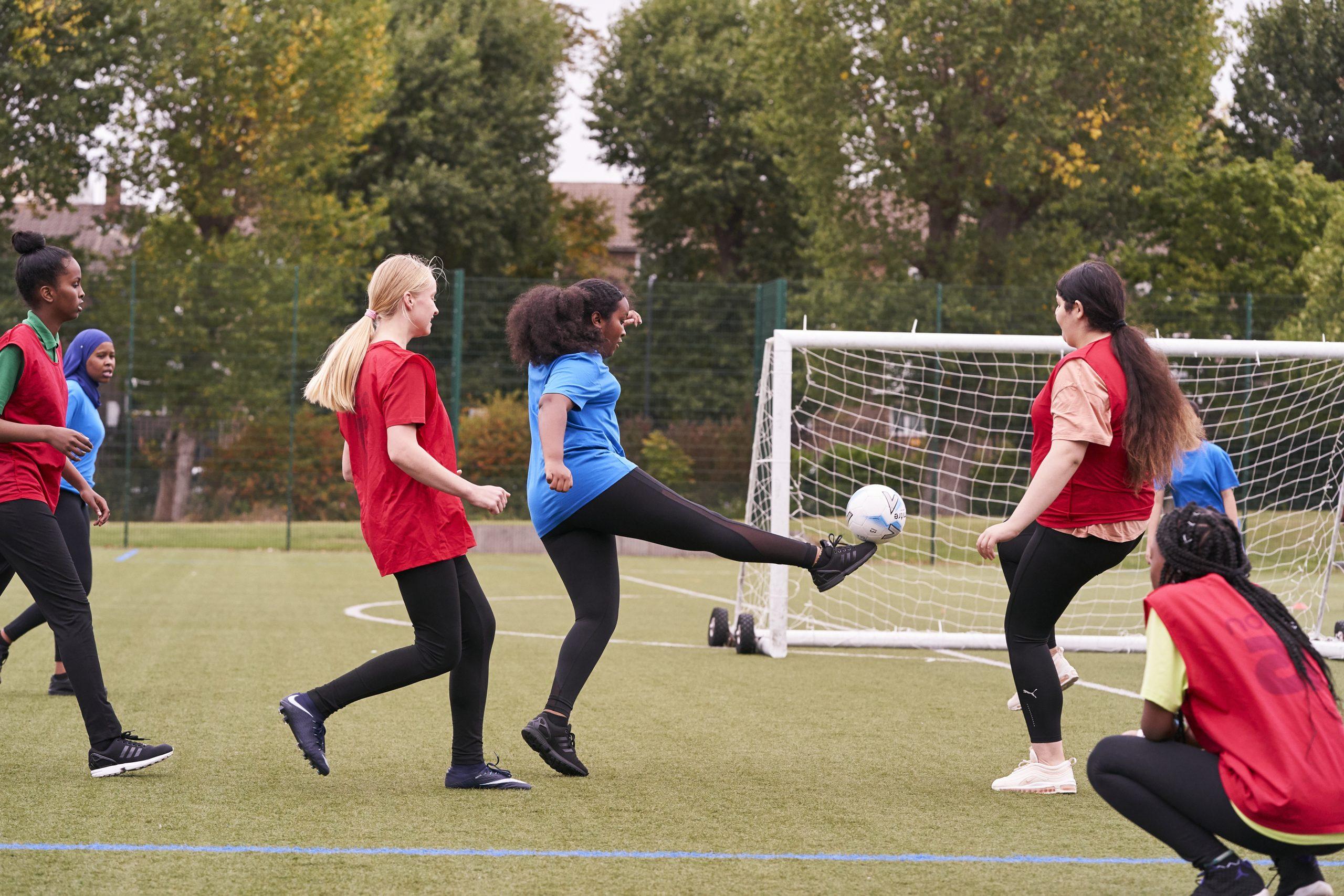 Teenage girls playing football