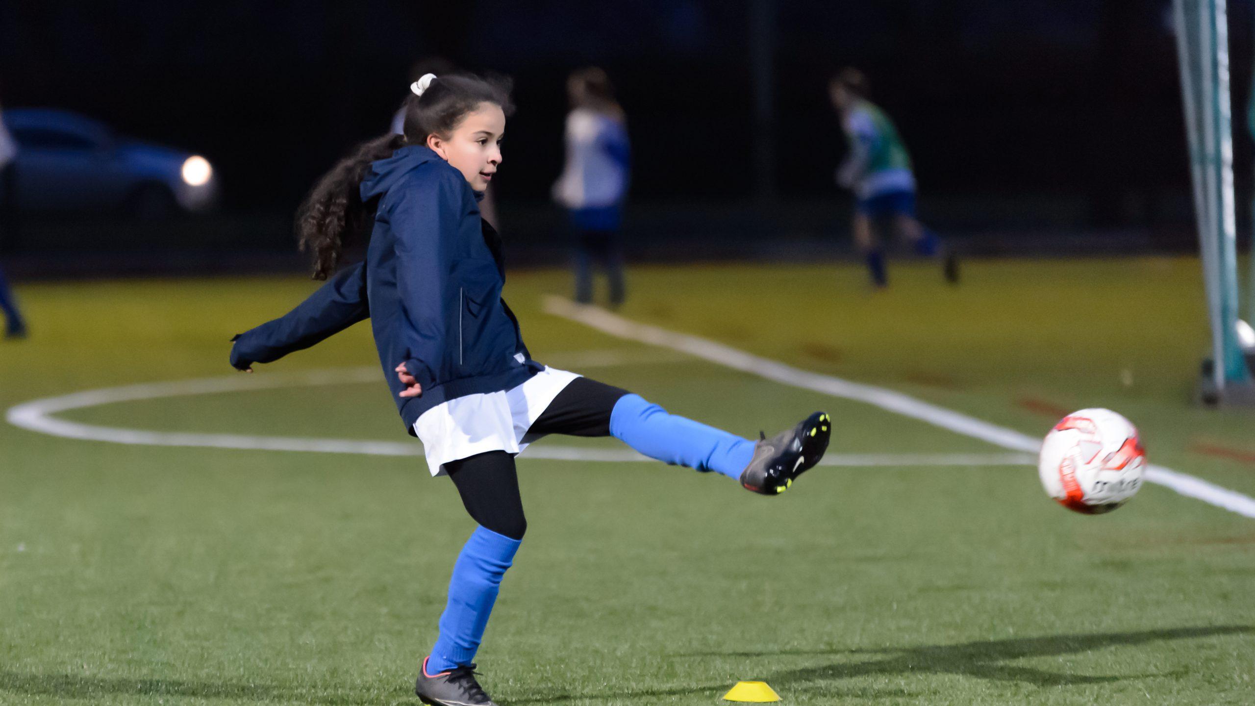 Young girl playing football