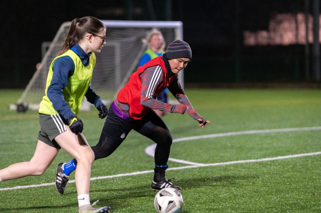 Two young women playing football