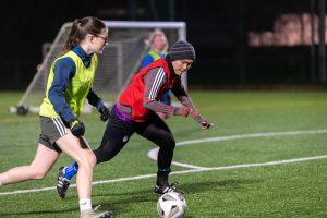 Two young women playing football