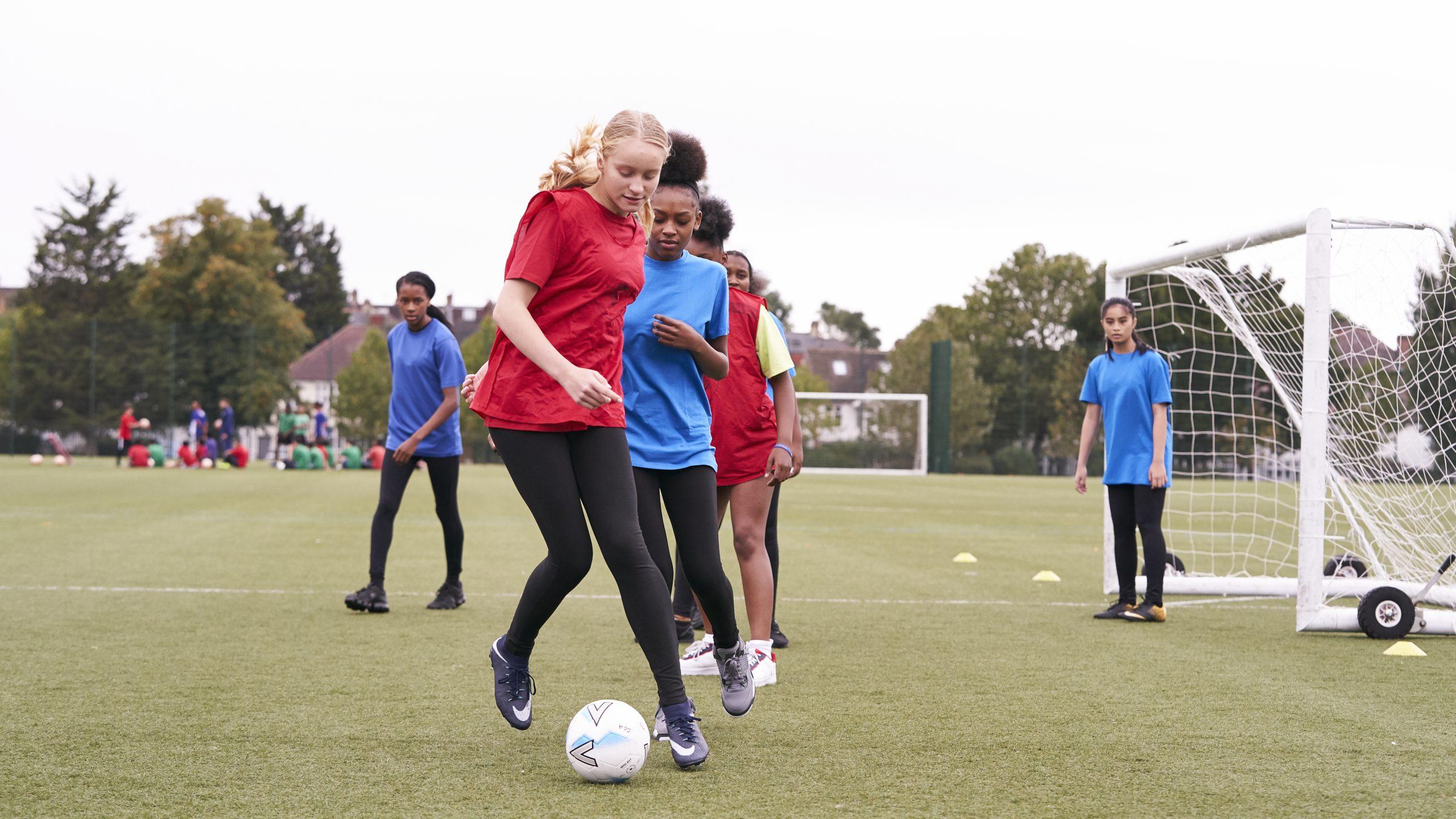 Teenage girls playing football