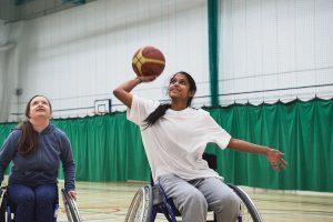 A south Asian teenage girl playing wheelchair basketball