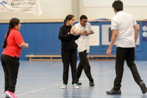 A group of secondary school students playing basketball together