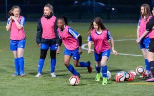 Teenage girls playing football