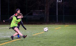 Two young women playing football 