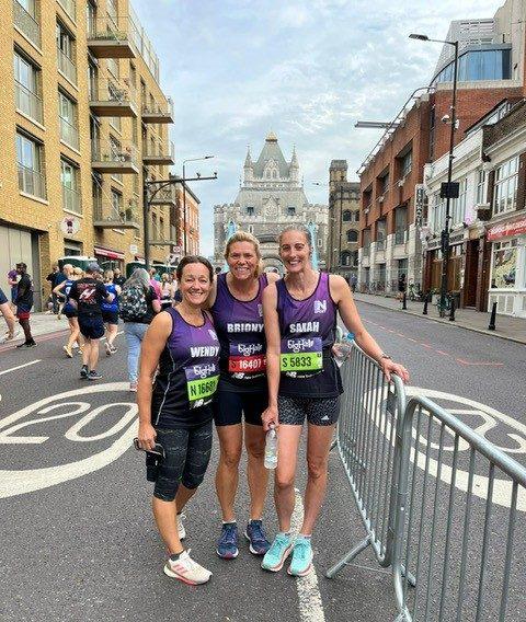 Three women posing after running a race for Women in Sport